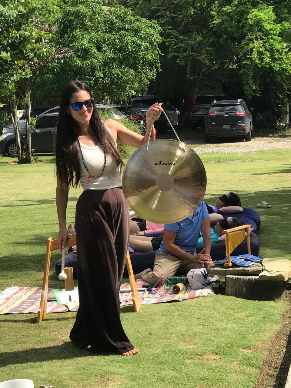 Marlyn sosteniendo un gong gong durante la sesión al aire libre